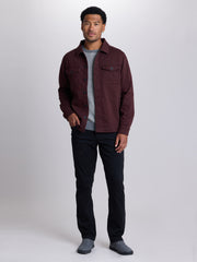 A man modeling a dark burgundy button-up overshirt over a gray knit sweater, black pants, and gray slip-on shoes, photographed against a light gray studio background. | Dark Oxblood