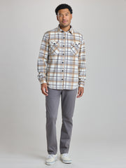 A man modeling a long-sleeve plaid button-up shirt in beige, brown, and white, paired with gray trousers and white sneakers, against a light gray studio background. | Steam